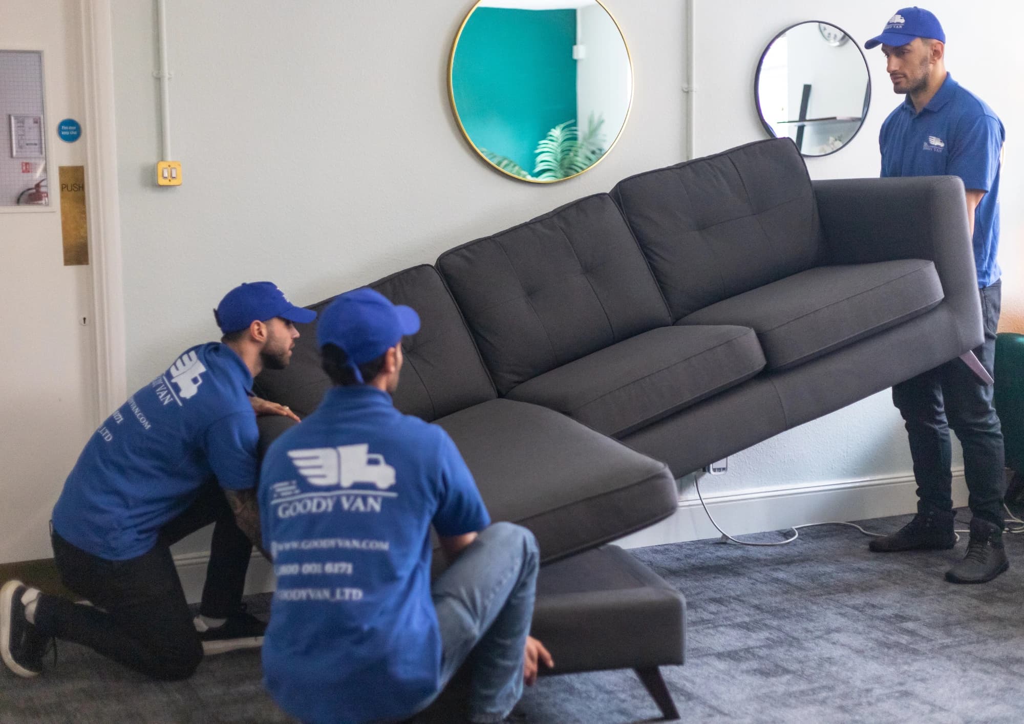 GoodyVan movers carrying a sectional sofa during a London house removal
