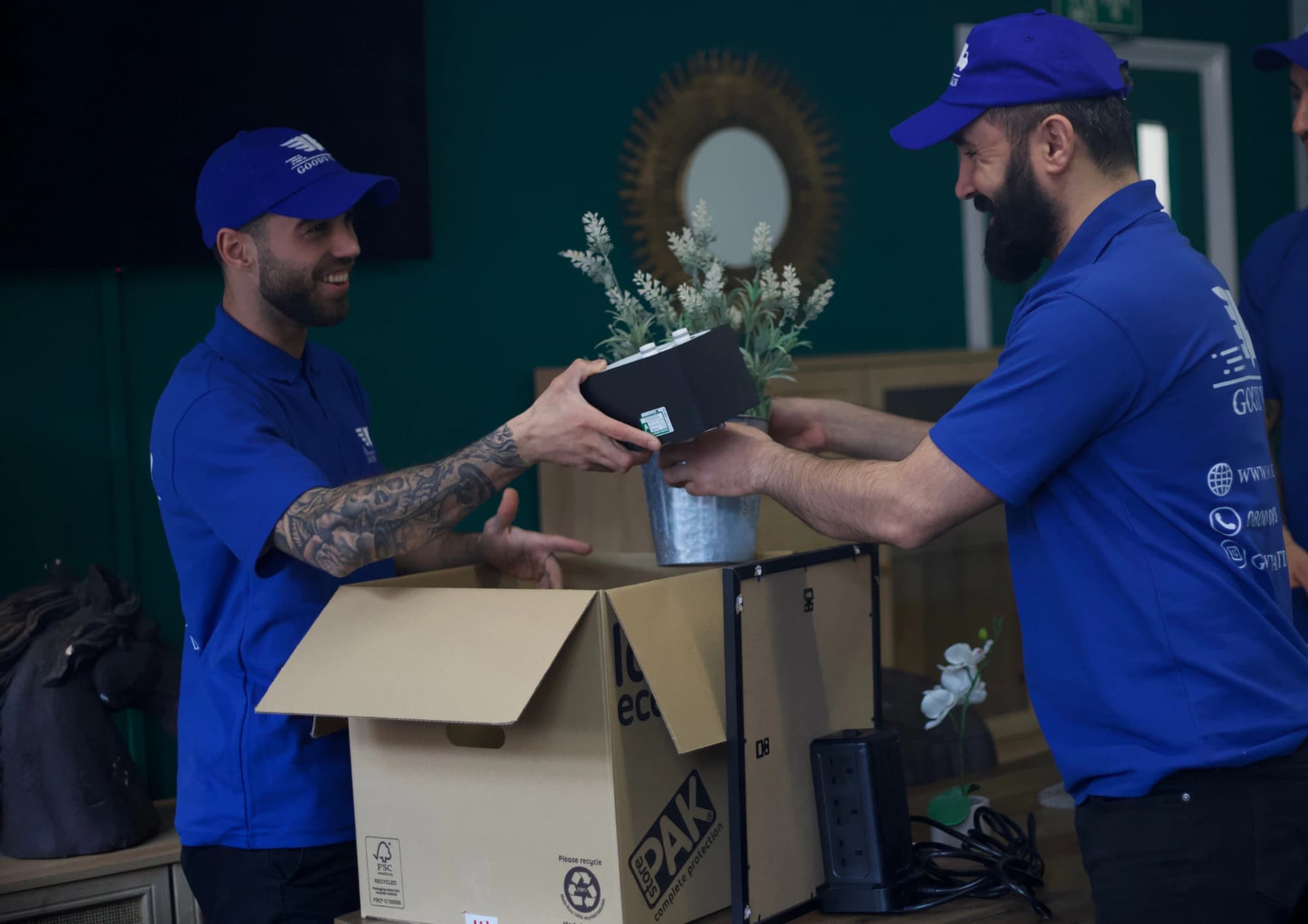 GoodyVan team packing household items into labelled moving boxes